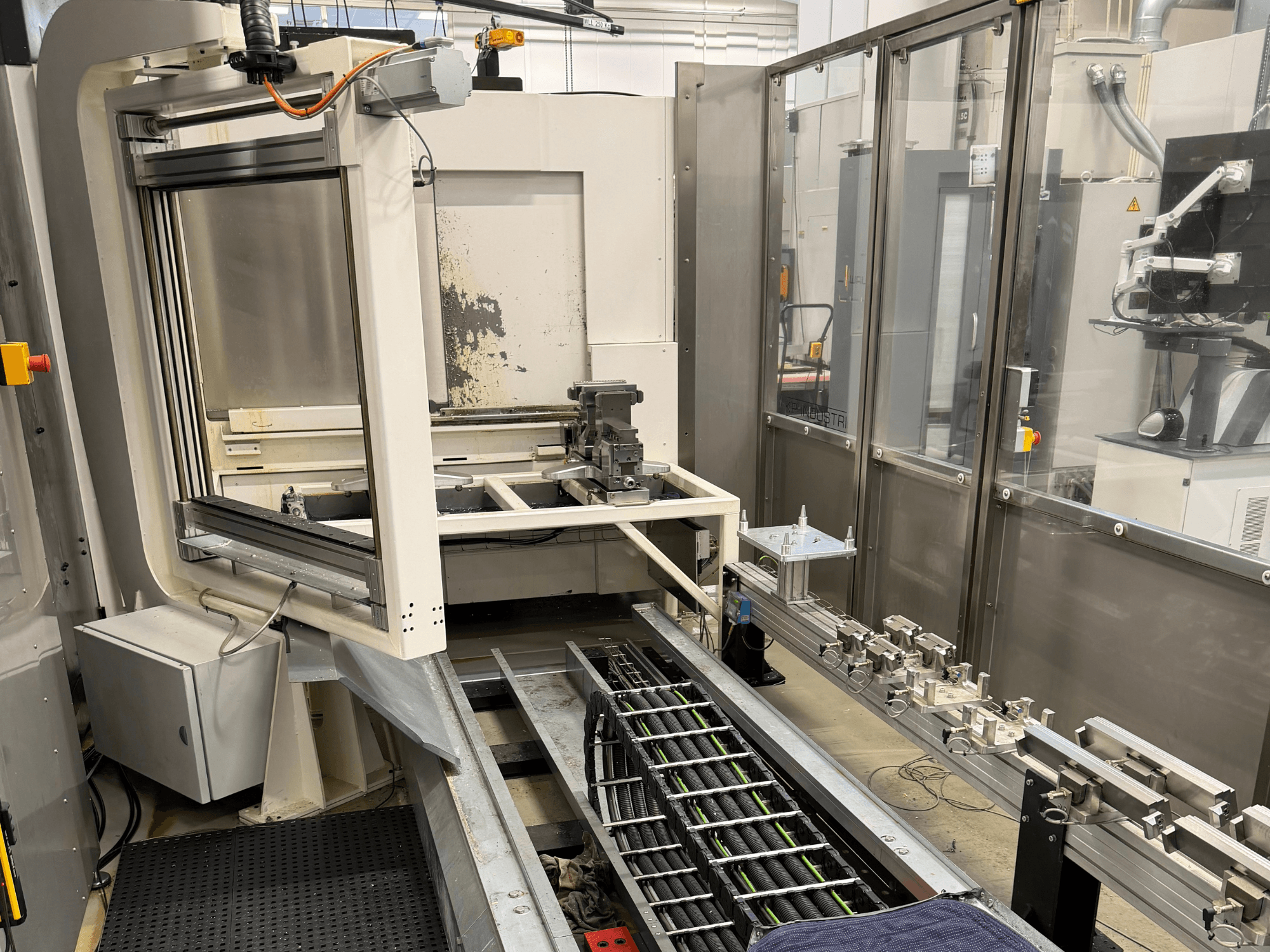 Automated industrial workstation showcasing a robotic arm, rail system, and control panel in a side view.