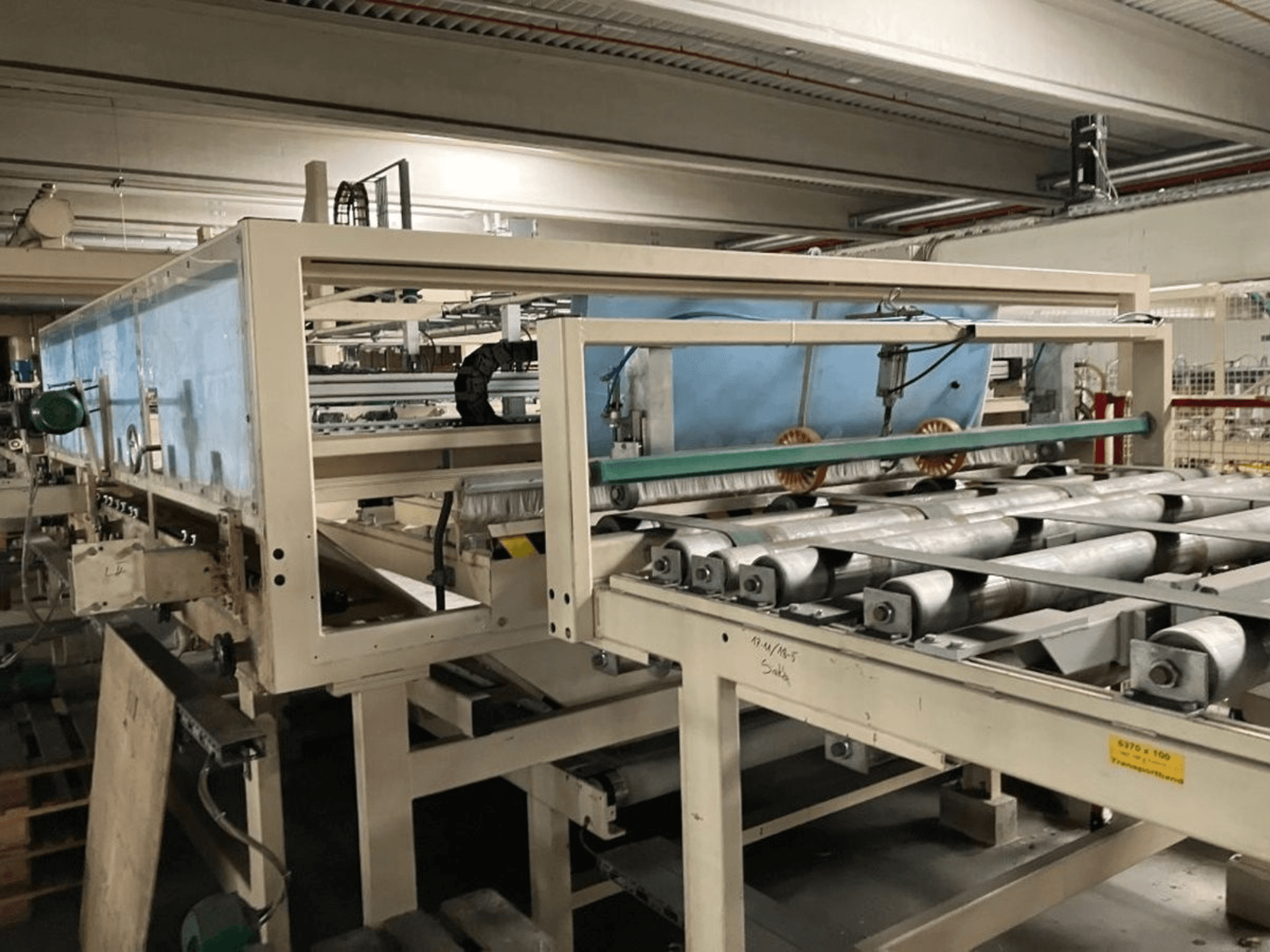 Prensa laminadora KT-F-1E de WEMHÖNER, vista lateral, con rodillos y controles para el procesamiento de material en una fábrica.