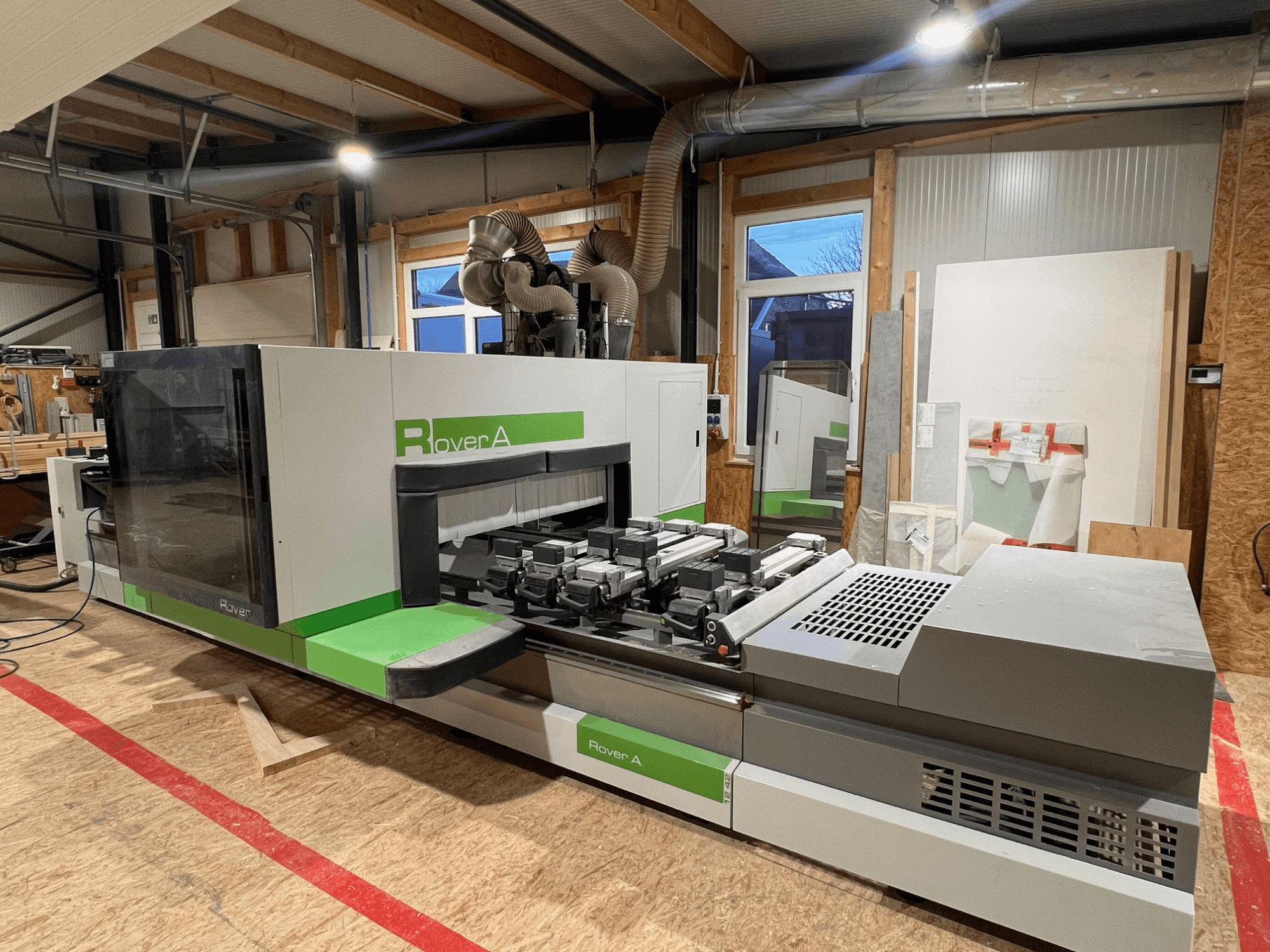 Centro de mecanizado de madera CNC BIESSE Rover A 1242, vista frontal mostrando el panel de control y la zona de corte en un entorno de taller.