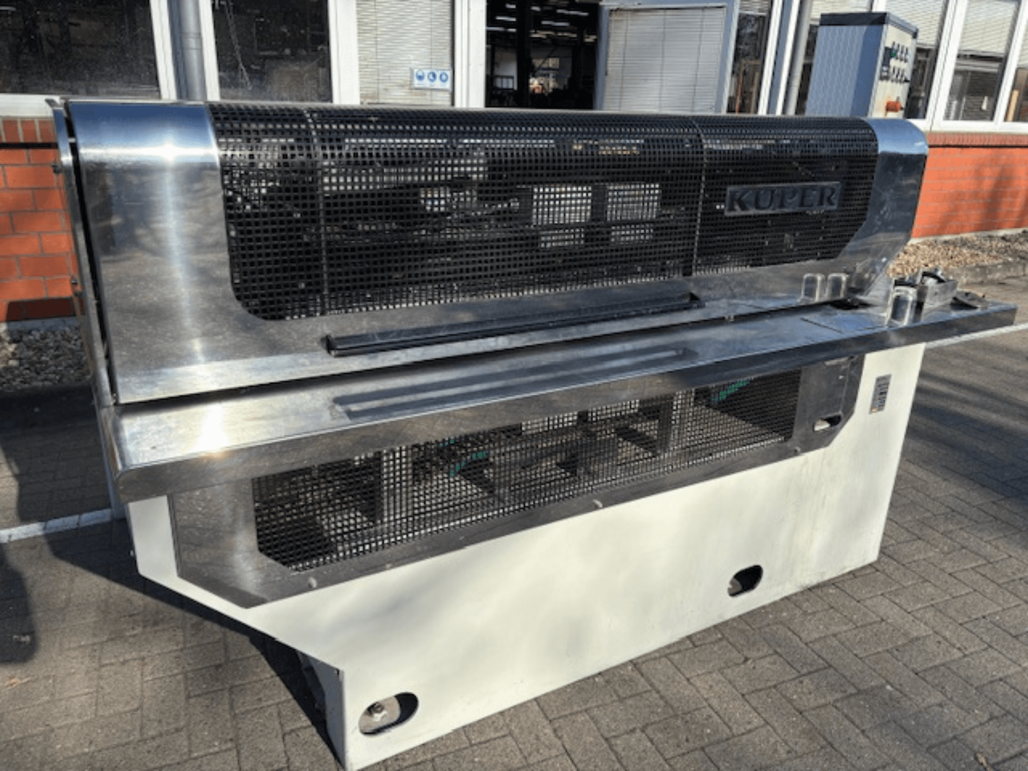 Guillotina de chapa KUPER FLI, vista frontal, con cuerpo de acero inoxidable y malla protectora para un funcionamiento seguro.