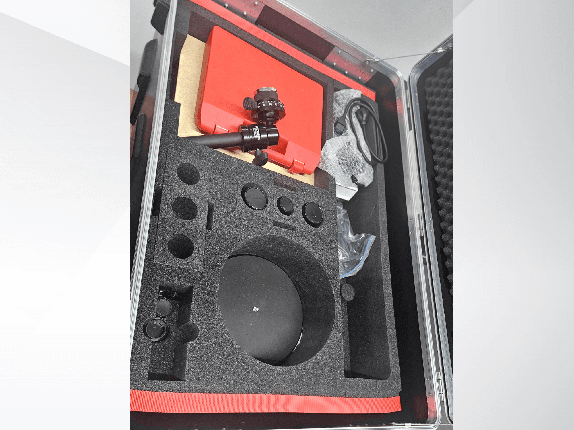 Componentes de la máquina de medición óptica ZEISS GOM ATOS 5 en un maletín forrado de espuma, con un objetivo, accesorios y embalaje protector.