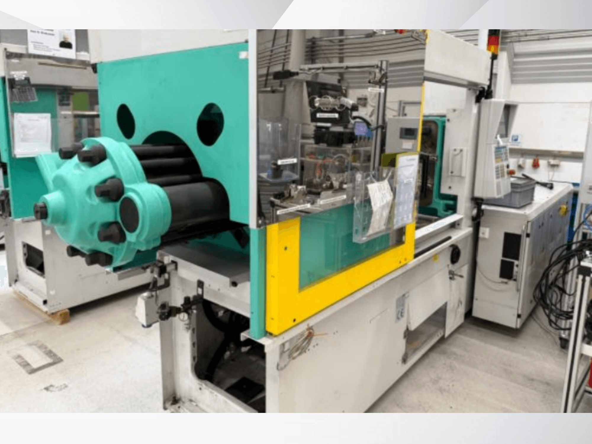 Injection molding machine, light blue and yellow, front view, featuring a visible mold and control panel with labels.