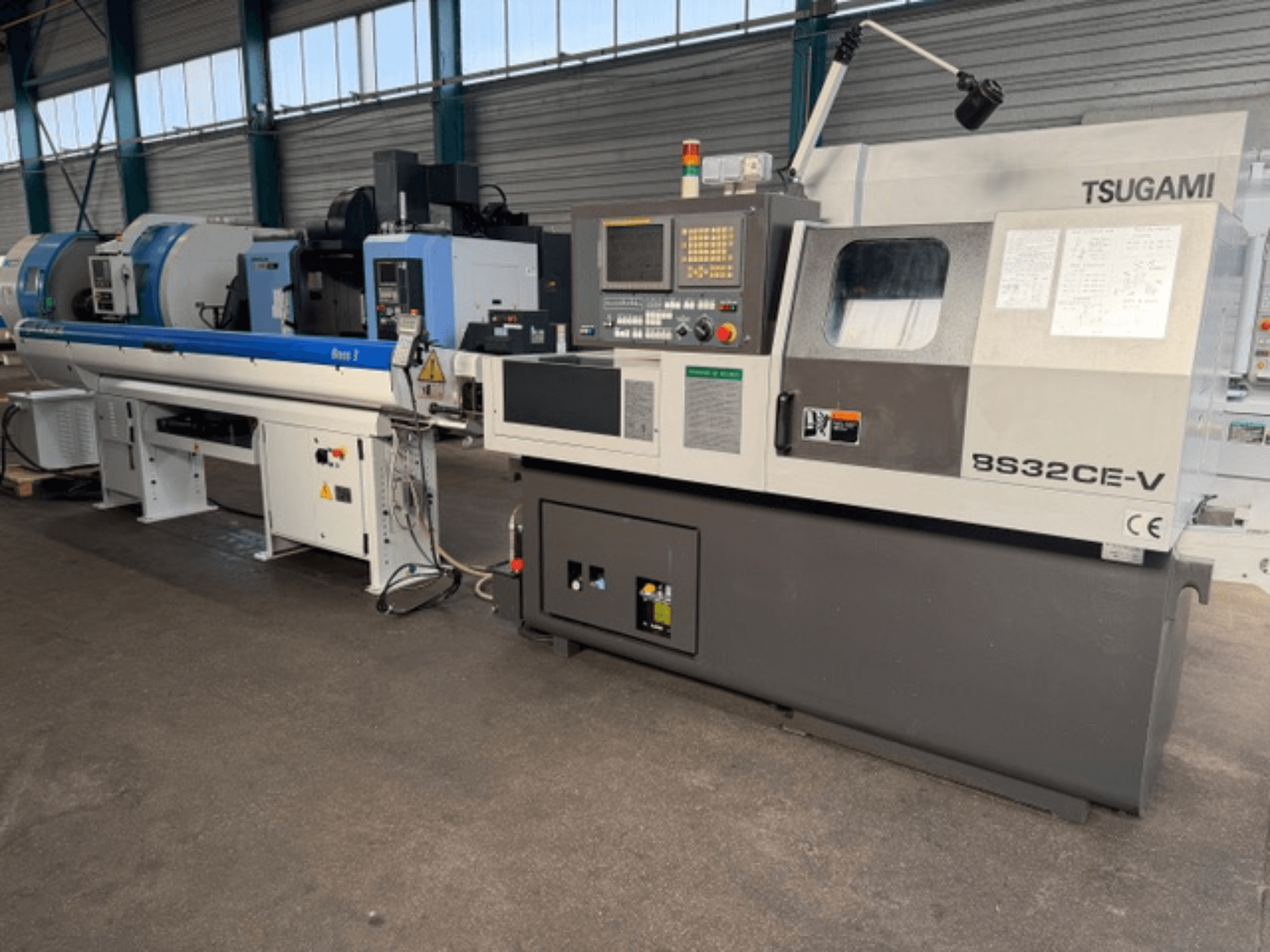 Máquina de torneado TSUGAMI BS32CE-V de tipo suizo en vista frontal, con panel de control y husillo acoplado.