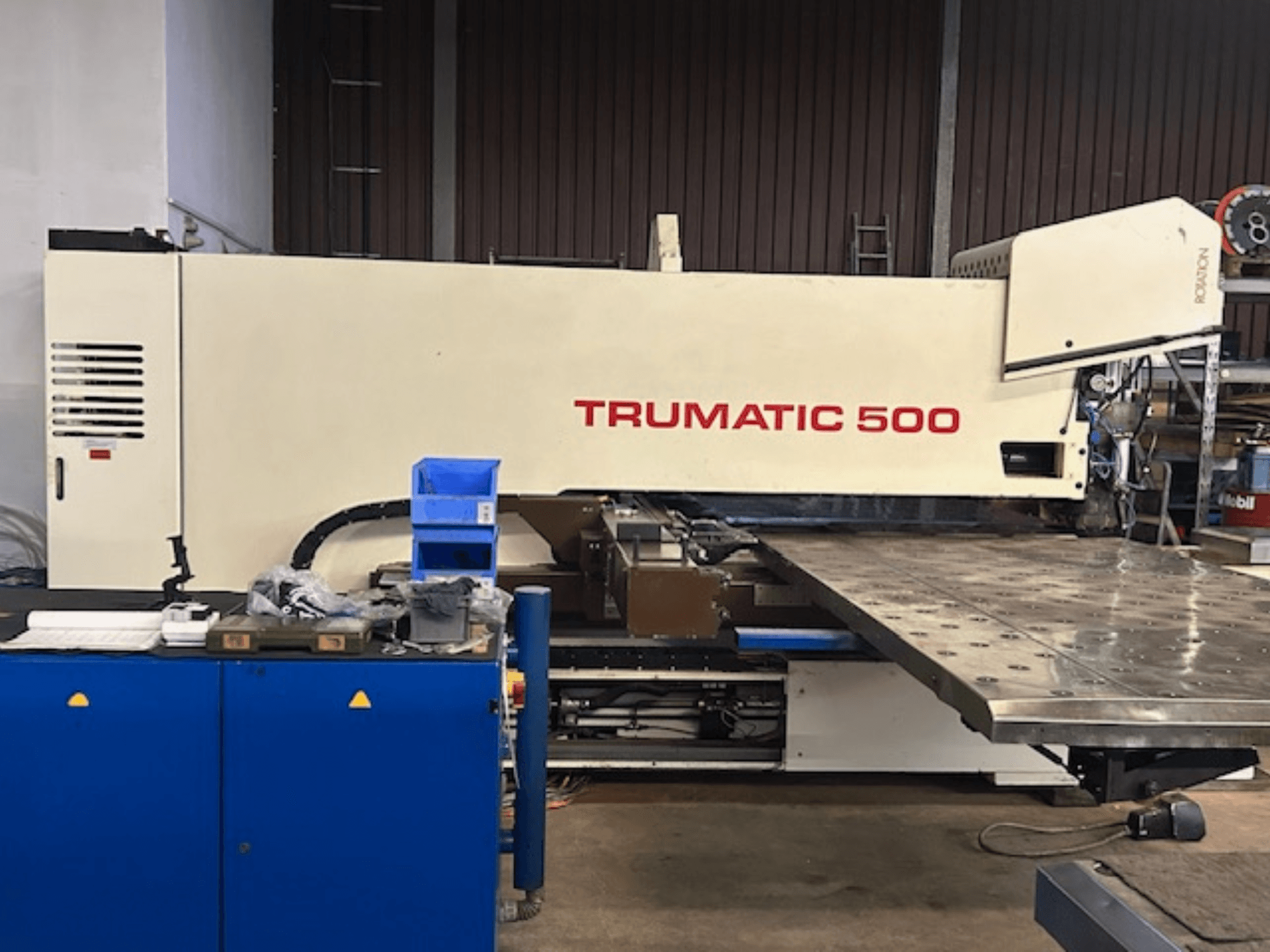 Punzonadora CNC TRUMPF TRUMATIC 500, vista frontal, con panel de control y una gran mesa de trabajo con superficie perforada.
