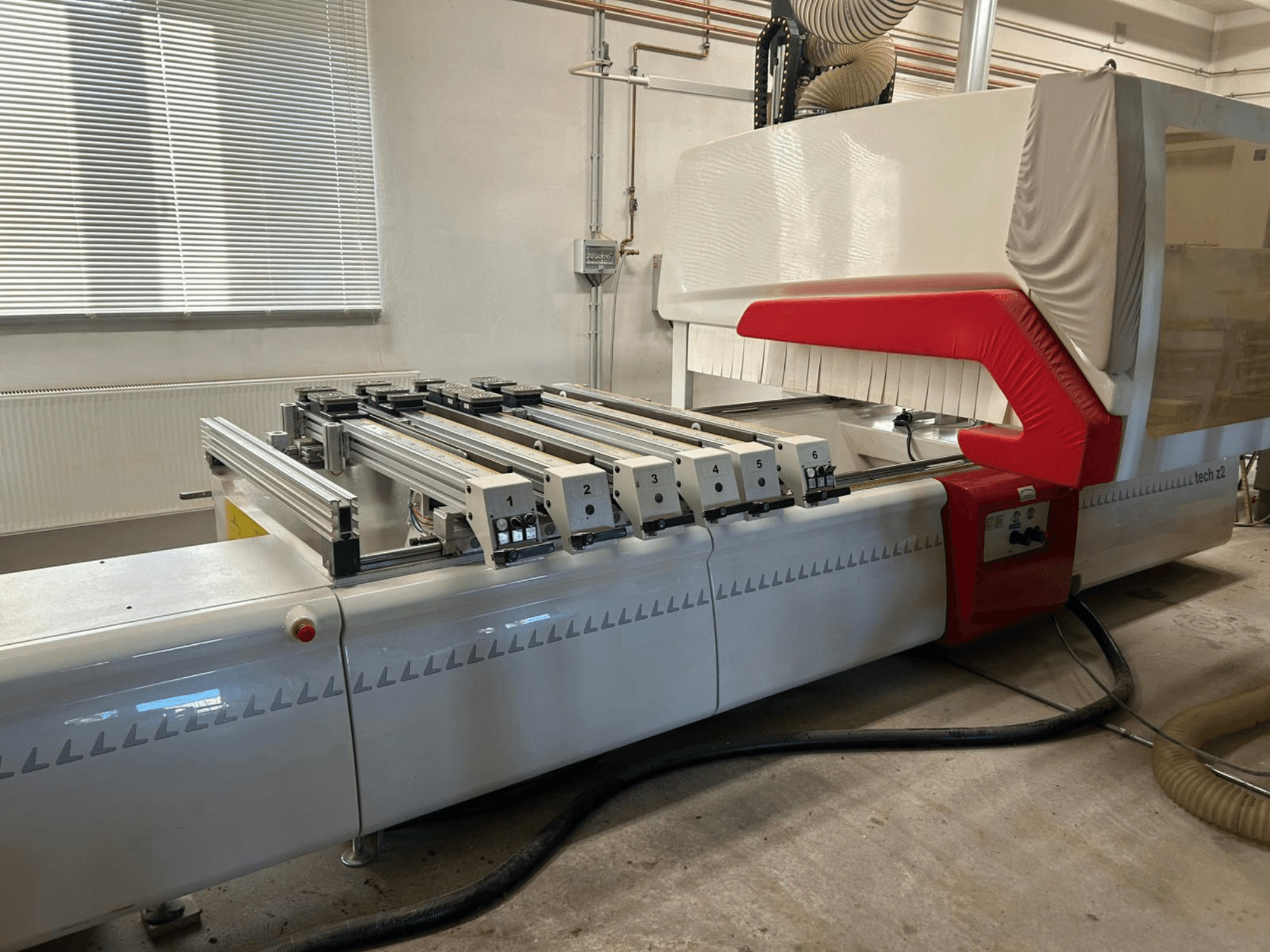 Mandrinadora de madera SCM TECH Z2-27-C, vista lateral, mostrando el panel de control y los raíles, con elementos de diseño rojos y blancos.